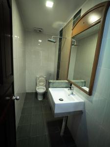 
a bathroom with a sink, toilet and mirror at Benarat Lodge in Mulu
