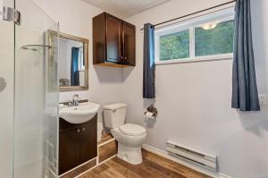 La salle de bains est pourvue de toilettes, d'un lavabo et d'une fenêtre. dans l'établissement The Oceanfront Inn on Stephens Bay, à Coal Harbour