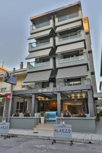 a tall building with a sign in front of it at Alarzo Rooms in Paralia Katerinis