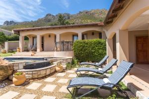 a group of chairs sitting outside of a house at Blue Horizon Guest House in Gordonʼs Bay