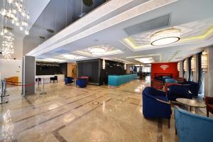 um grande átrio com cadeiras azuis e uma mesa em Best Western Plus Center Hotel em Ancara