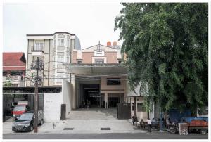 um grupo de pessoas sentadas fora de um edifício em RedDoorz near Kota Tua 2 em Jakarta