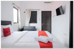 a bedroom with a large white bed with red pillows at RedDoorz near Kota Tua 2 in Jakarta