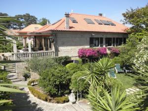 dom z czerwonym dachem i roślinami w obiekcie Hotel Playa Samil Vigo w mieście Vigo