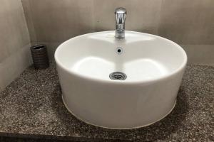 un lavandino bianco con un rubinetto in un bagno di Birdsnest Seaview Home a Dabolim