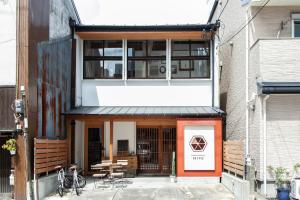 una casa con una puerta naranja y un edificio en Fukuoka Guesthouse HIVE en Fukuoka
