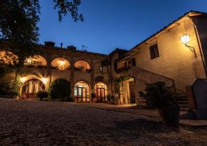 an old building with lights on a street at night at Agriturismo Casanova in Asciano