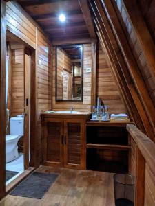 baño con lavabo en una cabaña de madera en Wonderful Citamiang by Anrha, en Puncak