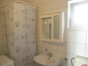 baño con lavabo y cortina de ducha con pescado. en Apartments Diana, en Primošten