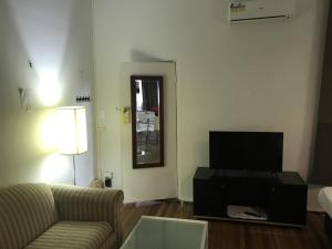 een woonkamer met een bank en een flatscreen-tv bij Belmont Palms Motel in Belmont