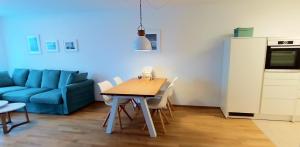 a living room with a table and a blue couch at BodenSEE City Apartment Friedrichshafen CASA GRAF in Friedrichshafen