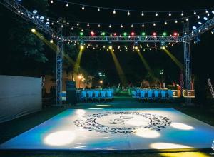 een podium met stoelen en een tafel met verlichting bij Hotel Raj Bagh Palace in Jaipur