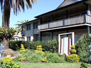 uma casa com uma bandeira no quintal da frente em Tokelau 2 Tuncurry Townhouse em Forster