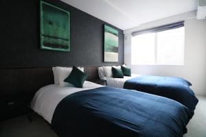 Un pat sau paturi într-o cameră la TAKETO STAY Kotoni