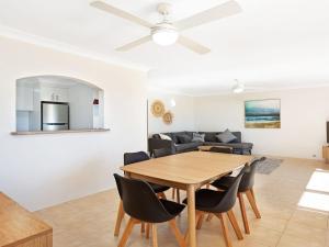 a dining room and living room with a table and chairs at Surfspray 2 Pebbly Beach in Forster
