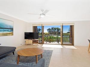 a living room with a tv and a couch and a table at Surfspray 2 Pebbly Beach in Forster
