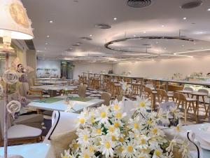 a restaurant with white tables and white flowers on them at Panda Hotel in Hong Kong