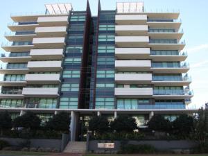 a tall apartment building with a statue in front of it at Strand Beachside 903 in Forster