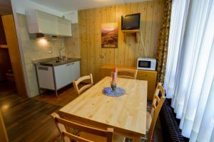 a kitchen with a wooden table with chairs and a small kitchen with a tableablish at Res. Amba appartamenti Solandra in Mezzana