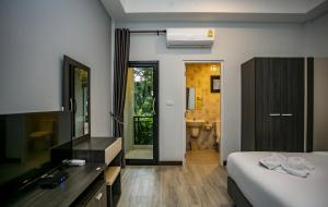 Habitación de hotel con cama y baño en โรงแรมกอดหมอน en Nakhon Pathom