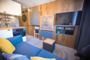 un salon avec un canapé bleu et une télévision dans l'établissement Superbe -Appartement 2 personnes - Tignes le Lac - 813 - Le Palafour, à Tignes