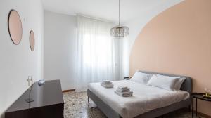 een witte slaapkamer met een bed met handdoeken erop bij Italianway - Quarnaro 2 in Monza