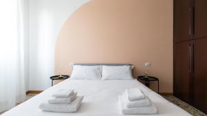 a bedroom with a white bed with two white towels at Italianway - Quarnaro 2 in Monza