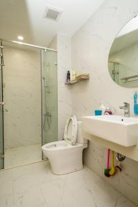La salle de bains est pourvue de toilettes, d'un lavabo et d'une douche. dans l'établissement Căn hộ TMS Pullman cao cấp Studio có ban công view biển - Golden Wave Homestay, à Quy Nhơn