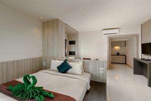 a hotel room with a bed with a green bow on it at Nakara Long Beach Resort - SHA Extra Plus in Ko Lanta