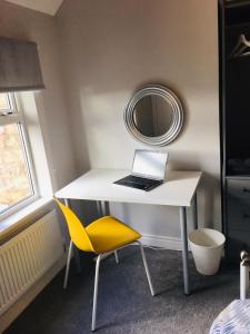 una scrivania bianca con un computer portatile e una sedia gialla di Snowdrop Cottage nr Alton Towers & Peak District, Sleeps 4+2 a Cauldon