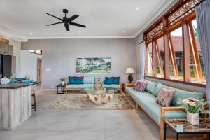 un soggiorno con divano e tavolo di Wake in Paradise Lebah Villas Pool Kitchen Spa ad Ubud