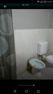 La salle de bains est pourvue de toilettes et d'un rideau de douche. dans l'établissement Duplex en Necochea, à Necochea