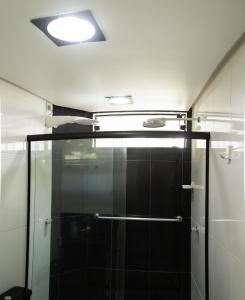 a shower stall with a glass door in a bathroom at Apartamento Na Praia do Guaibim - Valença-Ba in Guaibim