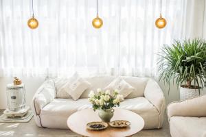 uma sala de estar com um sofá branco e uma mesa em Yuanshanqing·Stone Hill Seaview Guesthouse em Dali