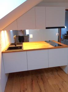 a kitchen with white cabinets and a sink at Brunetti Apartmány Jeseníky in Karlovice