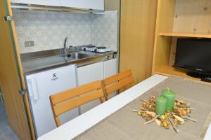 uma cozinha com uma mesa e um lavatório e uma mesa com uma mesa em Residence Bucaneve em Mezzana
