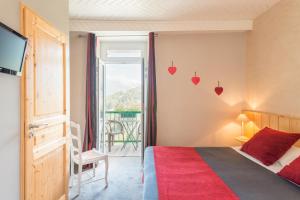 een slaapkamer met een bed en een raam met harten aan de muur bij Auberge Le Cabaliros in Argelès-Gazost