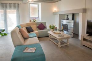 a living room with a couch and a fireplace at Occitanie Aquitaine gîte 5 pers -SPA privé-CLIM- Draps, vélos inclus - Equipé pour bébé in Soturac