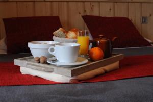 bandeja con alimentos para el desayuno y bebidas en una cama en Auberge Le Cabaliros, en Argelès-Gazost