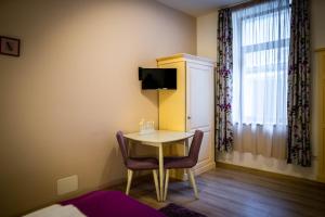 a room with a table and chairs and a window at Brassai Square in Braşov