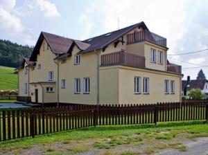 a large house with a fence in front of it at Brunetti Apartmány Jeseníky in Karlovice