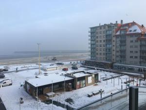 a train station in the snow with a train at Mare Nostrum 0402 in Nieuwpoort