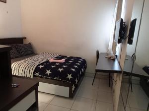 a small room with a bed and a desk at Bintang Property Aeropolis in Rawabambu