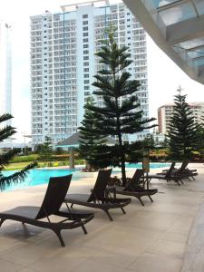 una fila di sedie a sdraio accanto alla piscina di Wind and Sea at Wind Residences a Tagaytay