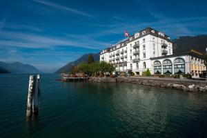 ein Hotel am Ufer eines Wasserkörpers in der Unterkunft Seehotel Waldstätterhof Swiss Quality in Brunnen