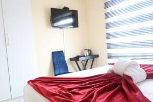 a bedroom with a red blanket on a bed at KwaZikode Bed & Breakfast in Meyerton