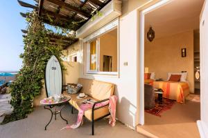 une chambre avec un canapé et une planche de surf sur une terrasse dans l'établissement Aftas Trip, à Mirleft
