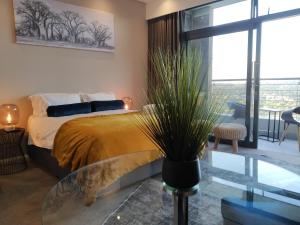 - une chambre avec un lit et une table en verre dans l'établissement The Residence Luxury Studio - Menlyn Maine, à Pretoria