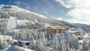 a resort in the snow with a mountain in the background at Das KATSCHBERG Superior in Katschberghöhe