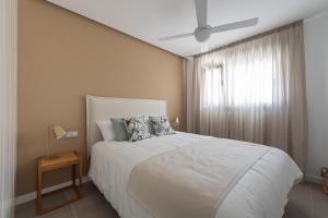 a bedroom with a white bed with a ceiling fan at Royal Flats in Las Palmas de Gran Canaria